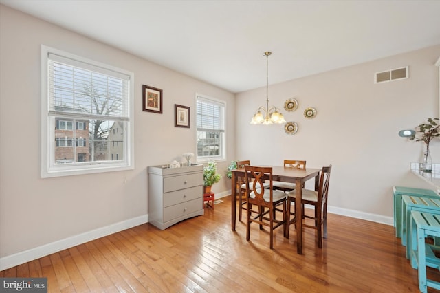 dining area with a chandelier and light hardwood / wood-style floors