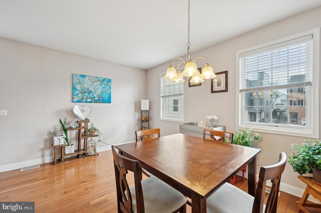 dining area featuring an inviting chandelier, plenty of natural light, and light hardwood / wood-style flooring