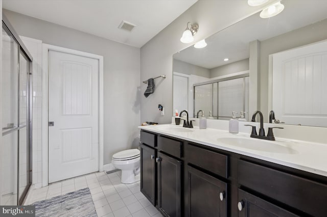 bathroom featuring tile patterned flooring, vanity, toilet, and an enclosed shower