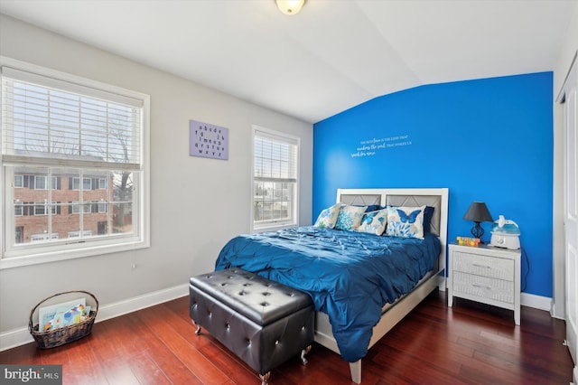 bedroom featuring dark hardwood / wood-style floors, vaulted ceiling, and multiple windows