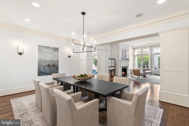 948 Melvin Rd, Annapolis, MD 21403 - dining room featuring crown molding, dark wood-style floors, recessed lighting, baseboards, and a warm lit fireplace