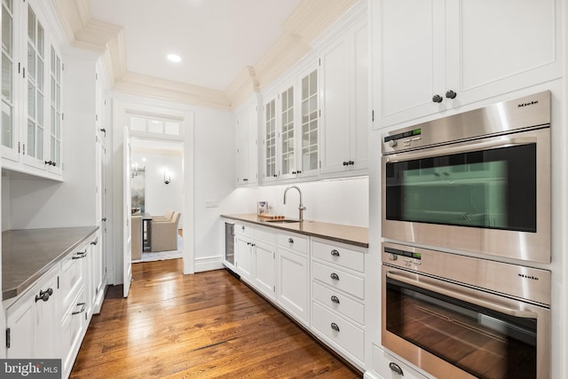948 Melvin Rd, Annapolis, MD 21403 - kitchen featuring a sink, white cabinetry, dark wood-type flooring, glass insert cabinets, and crown molding