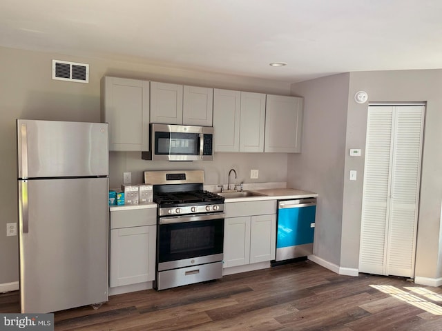 kitchen featuring white cabinetry, appliances with stainless steel finishes, sink, and dark wood-type flooring