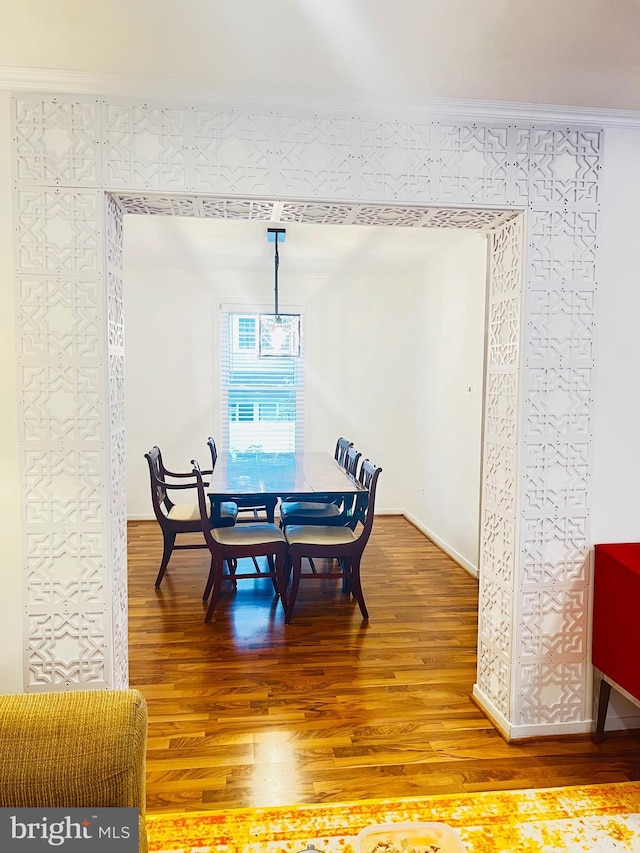 dining area with hardwood / wood-style flooring and crown molding