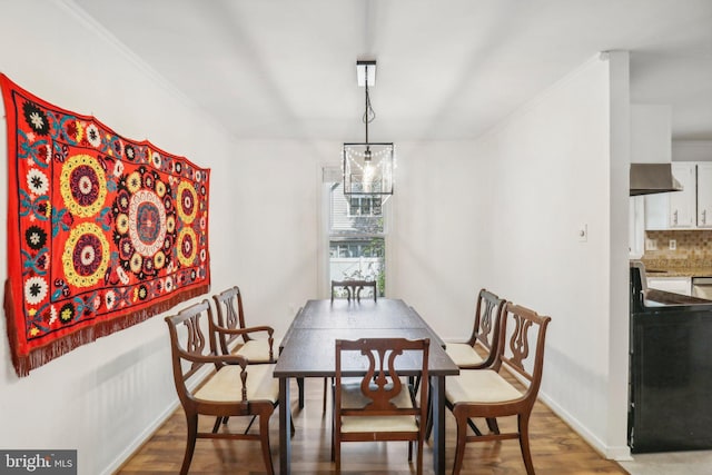 dining room featuring crown molding and light hardwood / wood-style flooring