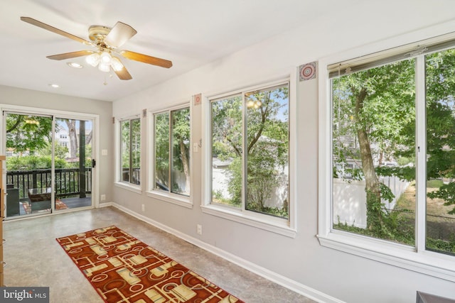 unfurnished sunroom featuring ceiling fan