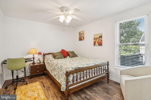 bedroom featuring dark hardwood / wood-style flooring, ornamental molding, and ceiling fan