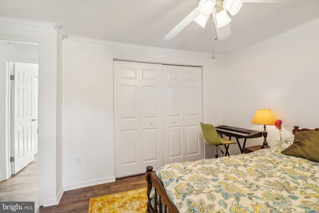 bedroom with crown molding, dark hardwood / wood-style floors, ceiling fan, and a closet