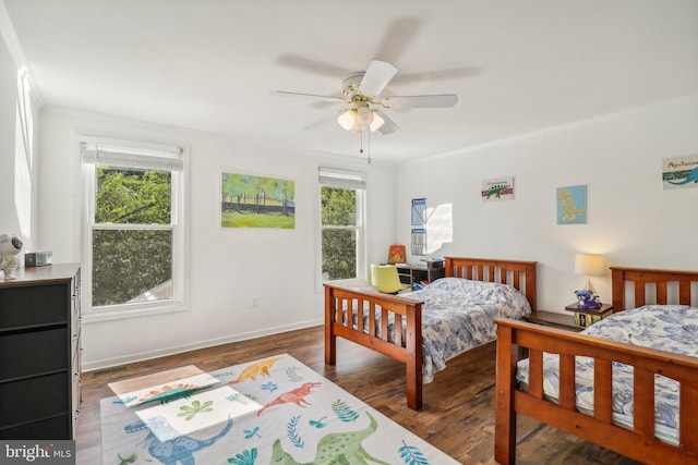 bedroom featuring multiple windows, dark wood-type flooring, and ceiling fan