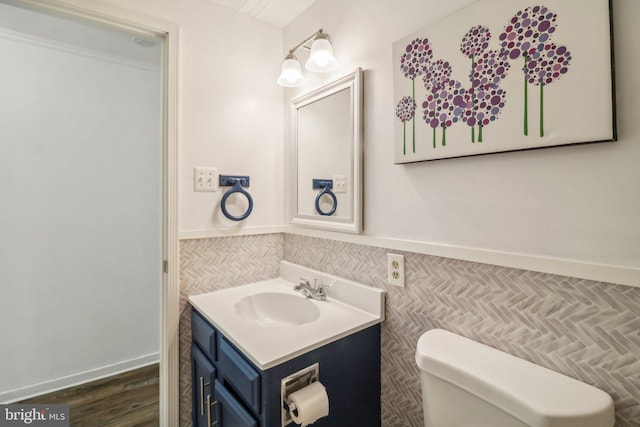 bathroom featuring hardwood / wood-style flooring, vanity, toilet, and tile walls