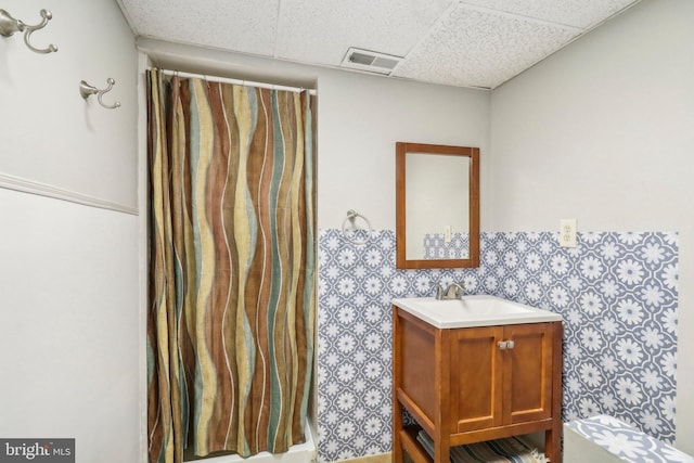 bathroom featuring vanity and a drop ceiling