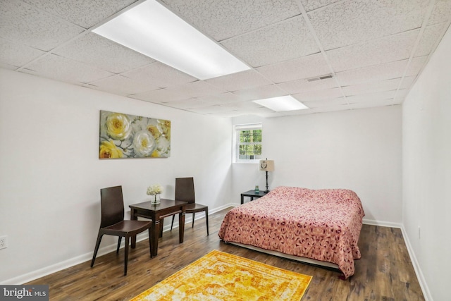 bedroom featuring dark wood-type flooring and a paneled ceiling