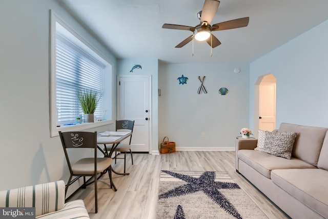 living room with ceiling fan and light hardwood / wood-style flooring