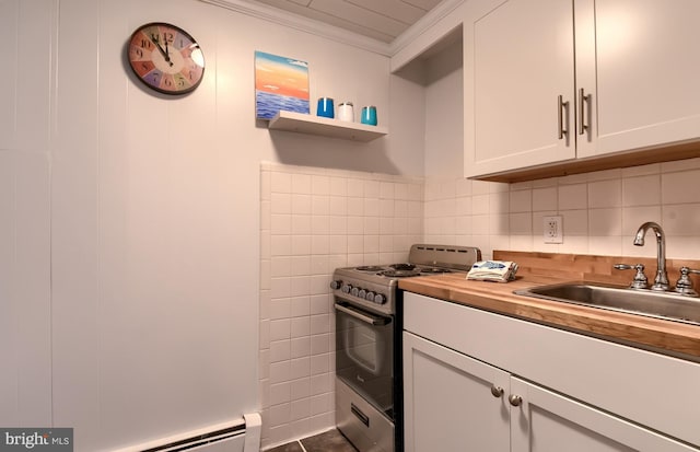 kitchen with sink, butcher block countertops, white cabinetry, ornamental molding, and stainless steel range with gas cooktop