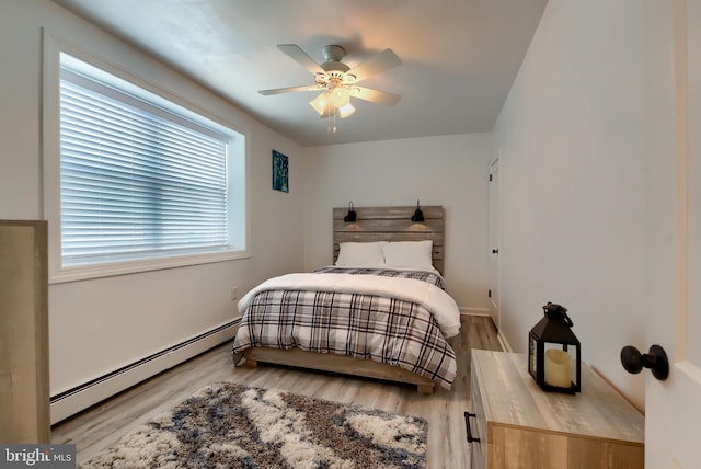 bedroom with ceiling fan, a baseboard radiator, and hardwood / wood-style floors