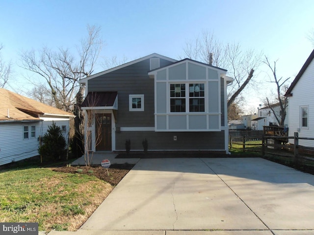 view of front of house with fence and a front lawn