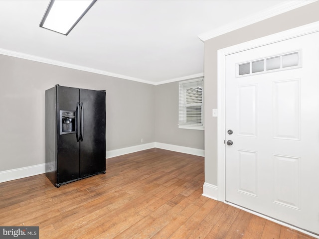 entryway featuring crown molding and light hardwood / wood-style floors