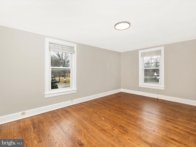 spare room featuring wood-type flooring and plenty of natural light