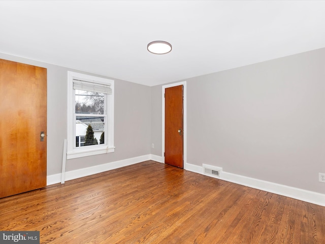 spare room featuring wood-type flooring