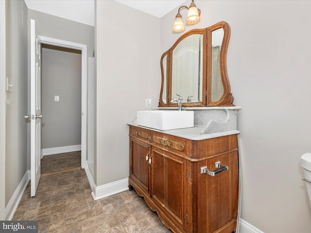 bathroom with vanity, a chandelier, and toilet