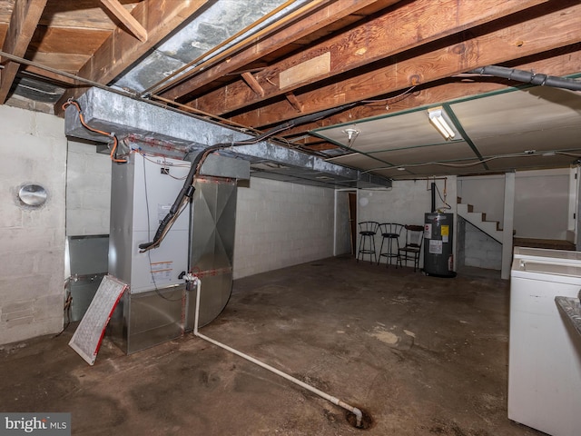 basement featuring heating unit, washer / clothes dryer, and water heater