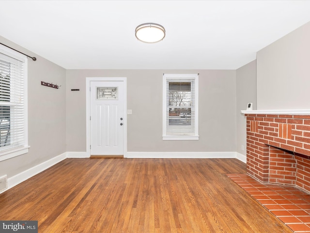 foyer entrance with hardwood / wood-style floors and a fireplace