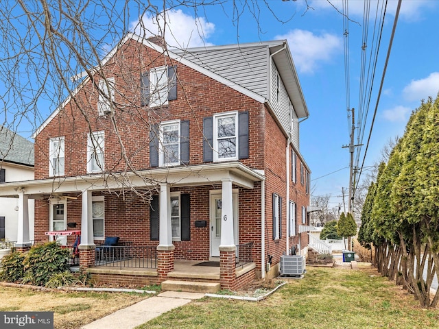 view of front of property featuring a porch, a front yard, and central air condition unit