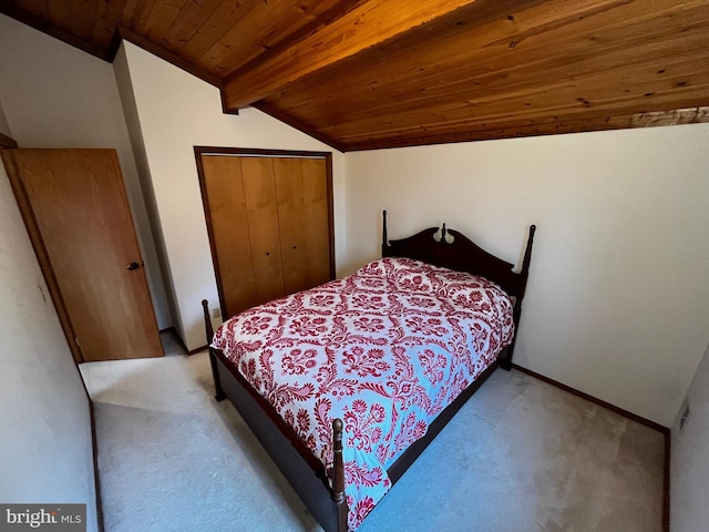 carpeted bedroom with lofted ceiling with beams, wood ceiling, and a closet