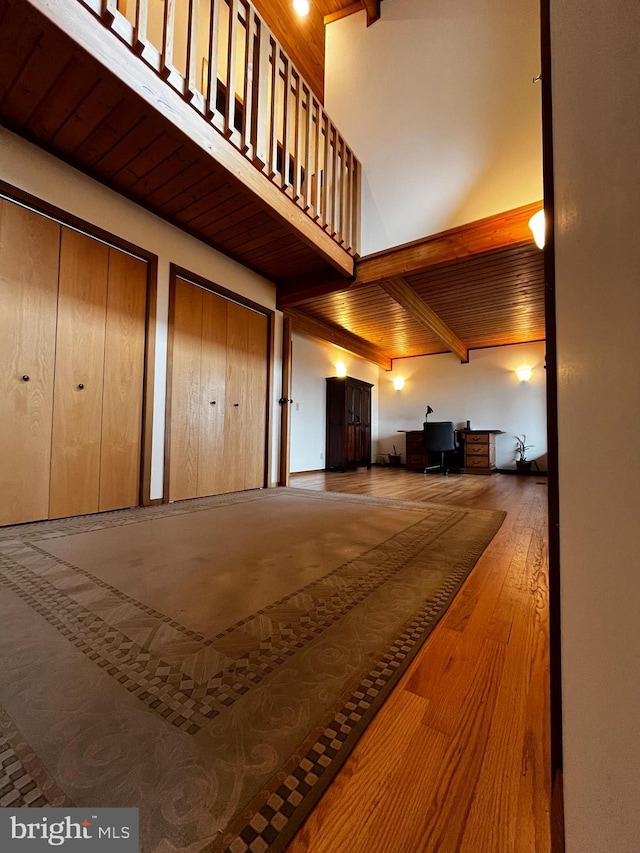 interior space featuring a towering ceiling, wood ceiling, and light hardwood / wood-style floors