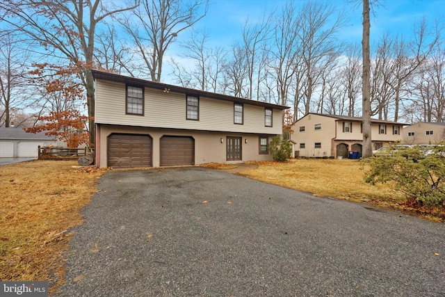 split foyer home featuring a garage and a front lawn