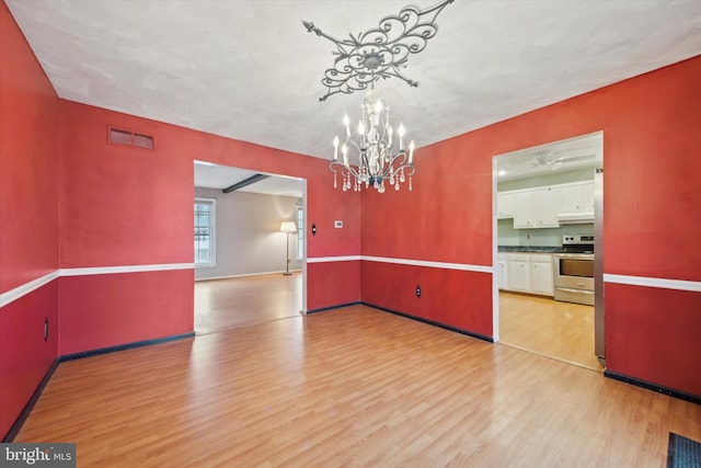 unfurnished dining area with light hardwood / wood-style flooring and a chandelier