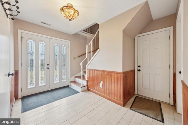 entrance foyer featuring wooden walls and light hardwood / wood-style flooring