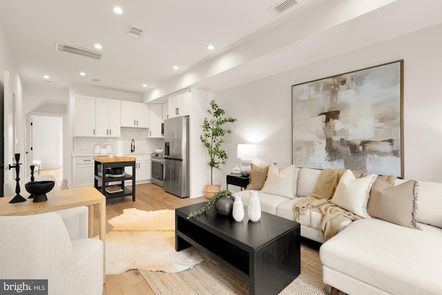 living room featuring sink and light wood-type flooring