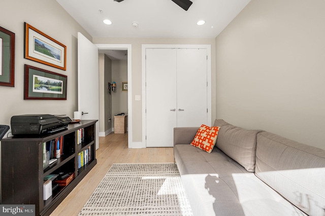 living area with light wood-type flooring, baseboards, and recessed lighting