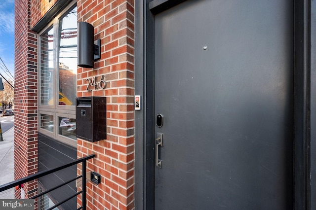 view of exterior entry featuring brick siding