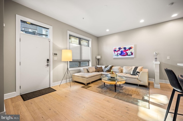 living area with light wood finished floors, recessed lighting, and baseboards