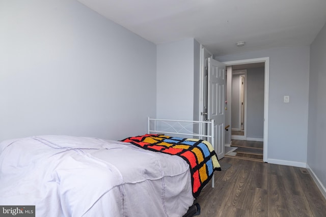 bedroom with dark hardwood / wood-style floors