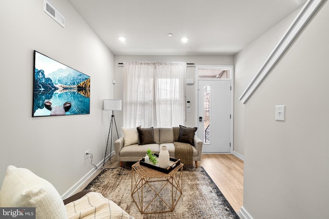 living room with light wood-style floors, baseboards, visible vents, and recessed lighting