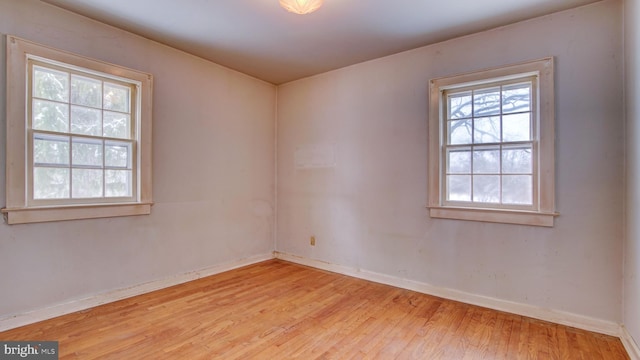 spare room with a wealth of natural light and light wood-type flooring