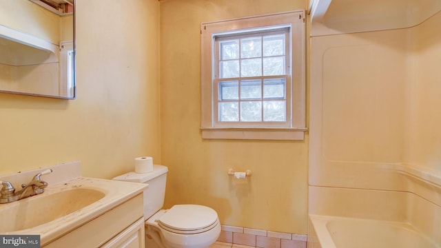 bathroom with tile patterned flooring, vanity, a tub, and toilet