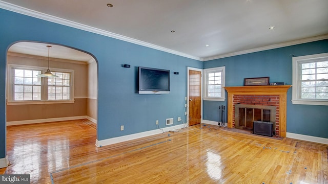 unfurnished living room featuring crown molding, a fireplace, and light hardwood / wood-style floors