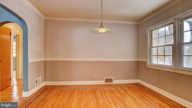 unfurnished dining area with wood-type flooring and crown molding