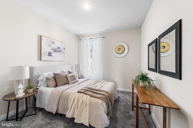 bedroom with baseboards and dark carpet