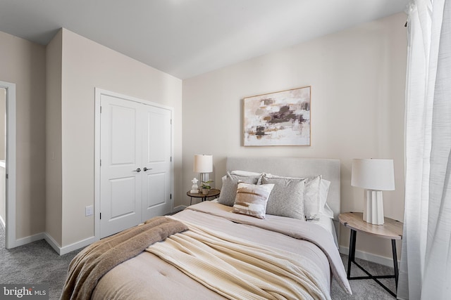 carpeted bedroom featuring baseboards and a closet