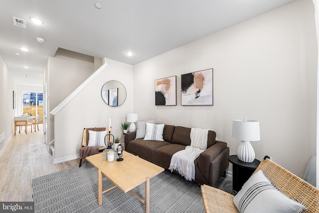 living room with visible vents, baseboards, wood finished floors, and recessed lighting