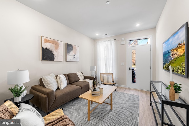 living area with light wood-type flooring and recessed lighting