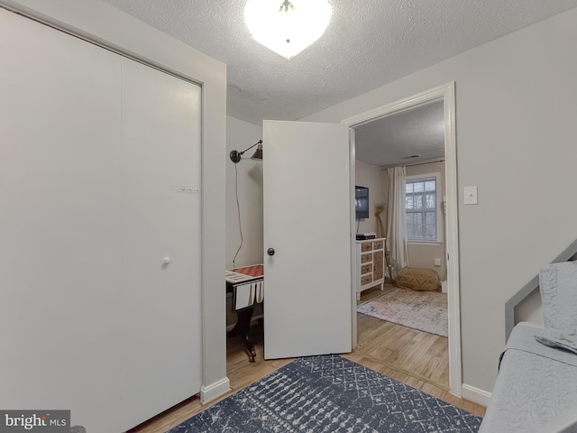 bedroom featuring a textured ceiling and light wood-type flooring