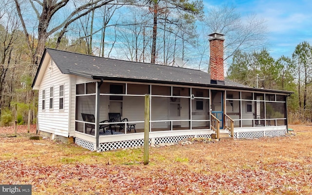 rear view of property featuring a sunroom