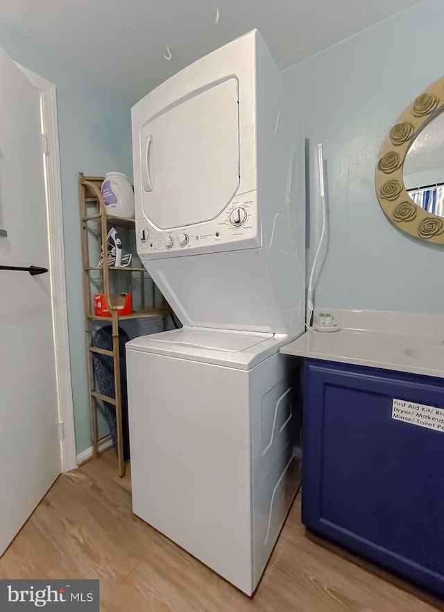 laundry area featuring stacked washer and dryer and light hardwood / wood-style floors