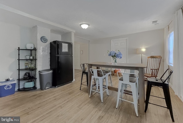 dining area featuring a textured ceiling and light hardwood / wood-style floors